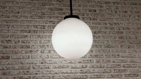 Modern White Globe Pendant Light Against Rustic White Exposed Brick Wall Stock Footage 330144946