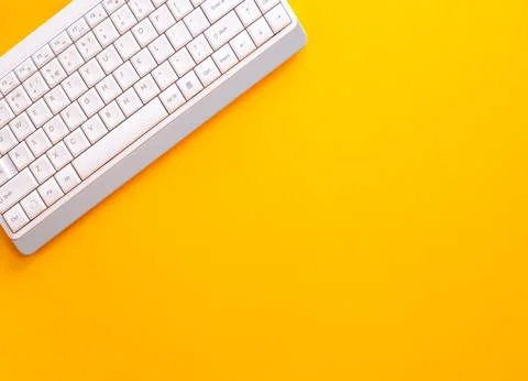 Modern white keyboard on yellow background, great design for any purpose. F.. Stock Photos