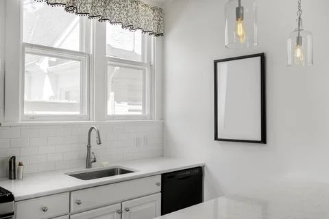 Modern White Kitchen With Natural Light And Minimalist Design Elements. Stock Photos