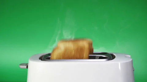 Modern white kitchen toaster with bread against green background ,slow  Stock Footage 124947583