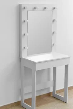 Modern white makeup dressing table with mirror and backlight against a whit.. Stock Photos