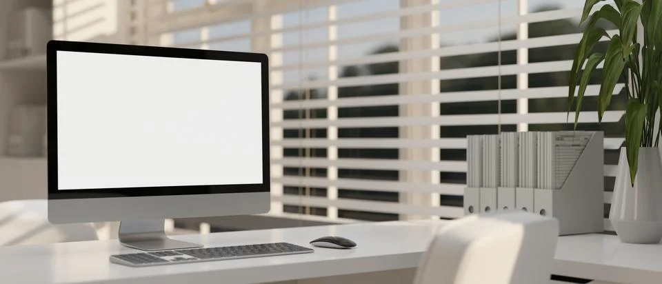 Modern white office with a computer white-screen mockup and office supplies.. Illustrazione stock