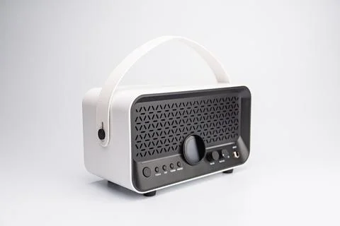 Modern white portable Bluetooth speaker with textured front, positioned off.. Stock Photos