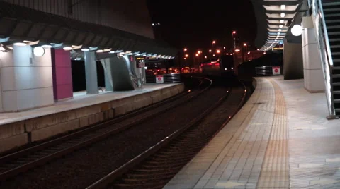 Modern white train arriving at an empty train station during late night hour Stock Footage 45806019