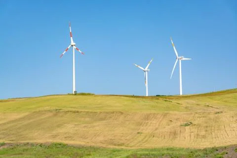 Modern wind farm with big wind turbines towers, source for renewable green en Stock Photos