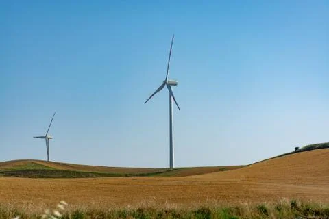 Modern wind farm with big wind turbines towers, source for renewable green en Stock Photos