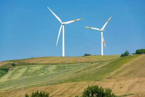 Modern wind farm with big wind turbines towers, source for renewable green en Stock Photos