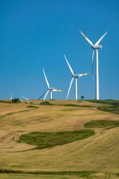 Modern wind farm with big wind turbines towers, source for renewable green en Stock Photos