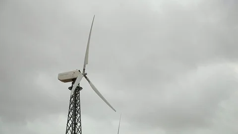 Modern wind generator closeup, cloudy grey sky bg Vidéo 97101300