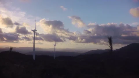 Modern wind generators standing on a mountain range against a dramatic evening s Stock Footage 341973354