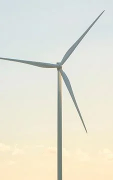 Modern wind turbine generating clean renewable energy against a pale sky Photos