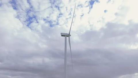 Modern wind turbine generating renewable energy against a cloudy sky Stock Footage 336202711