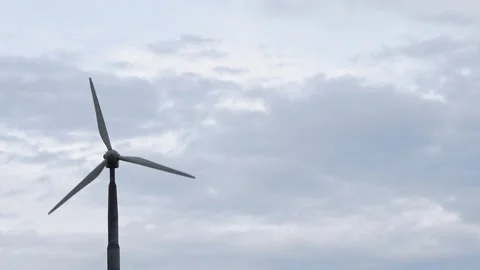 Modern wind turbine rotating against a dramatic, cloudy overcast sky background Stock Footage 337538328