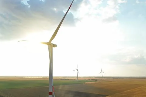 Modern windmill in field, space for text. Energy efficiency Stock Photos
