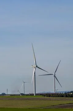 Modern windmills in open fields for renewable energy Stock Photos