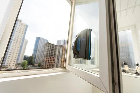 Modern window washer robot performs work on a dirty window. Cleaning the house Stock Photos