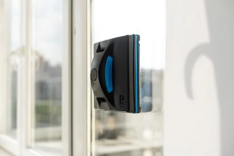 Modern window washer robot performs work on a dirty window. Cleaning the house Stock Photos