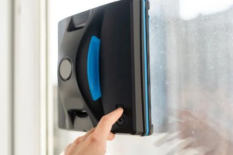 Modern window washer robot performs work on a dirty window. Cleaning the house Stock Photos