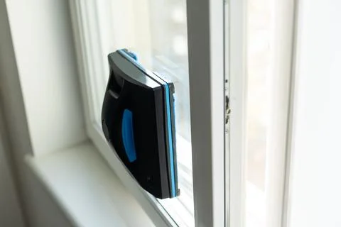 Modern window washer robot performs work on a dirty window. Cleaning the house Stock Photos