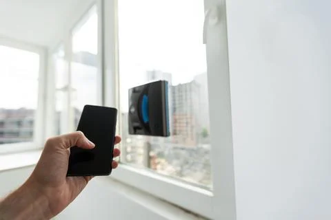 Modern window washer robot performs work on a dirty window. Cleaning the house Stock Photos