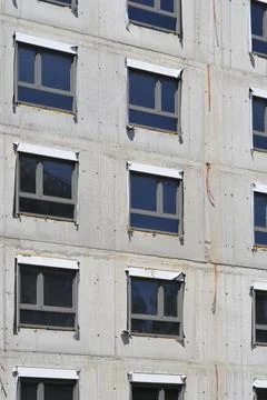 Modern Windows Installed on Raw Concrete Building Facade Stock Photos