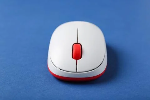 Modern wireless computer mouse on blue background, closeup Stock Photos