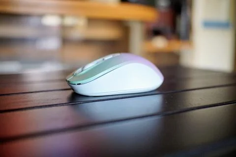 A modern wireless computer mouse with a type C plug is placed on a black table Stock Photos