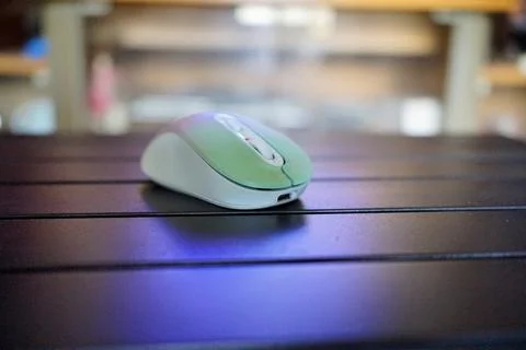 A modern wireless computer mouse with a type C plug is placed on a black table Stock Photos