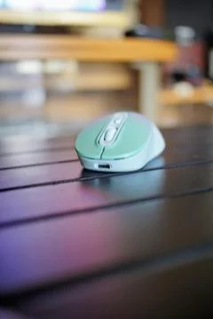A modern wireless computer mouse with a type C plug is placed on a black table Stock Photos
