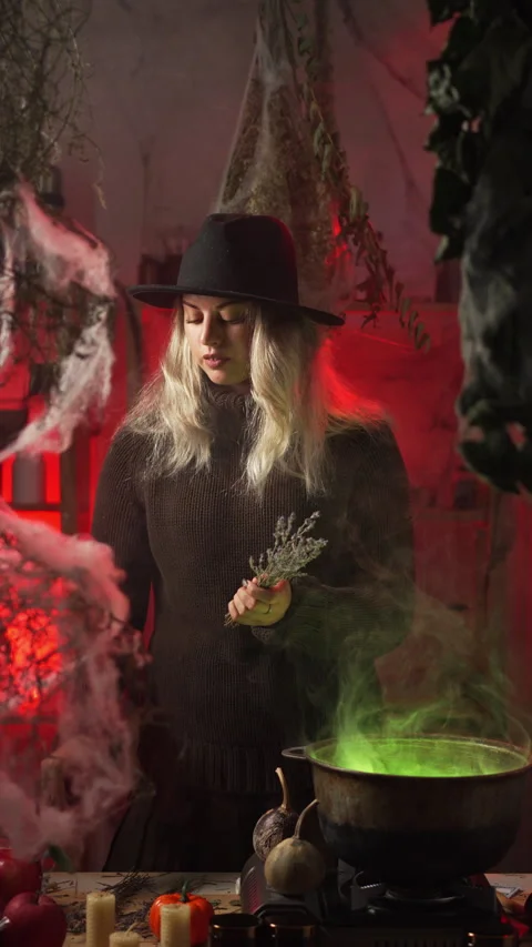 A modern witch at home, amidst cobwebs and dried herbs, prepares a poison o.. 動画素材 345427258