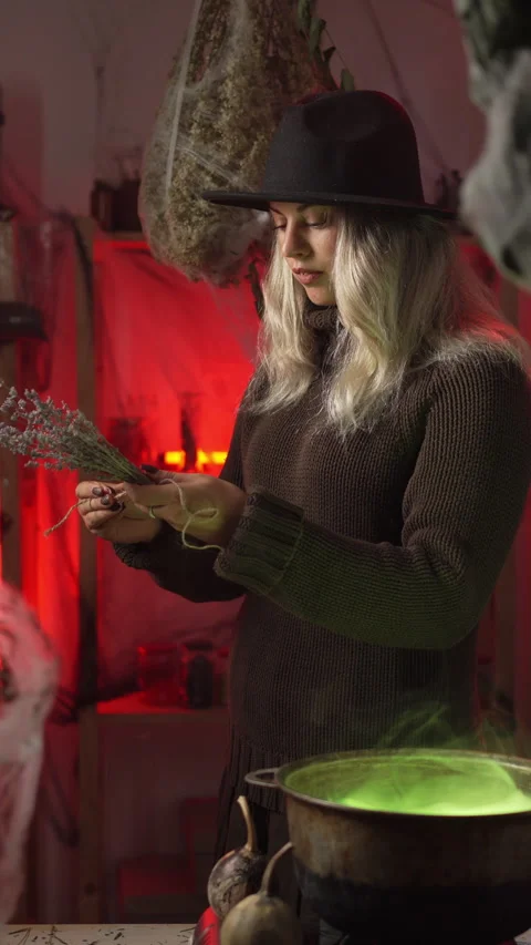 A modern witch at home, amidst cobwebs and dried herbs, prepares a poison o.. 動画素材 345427447