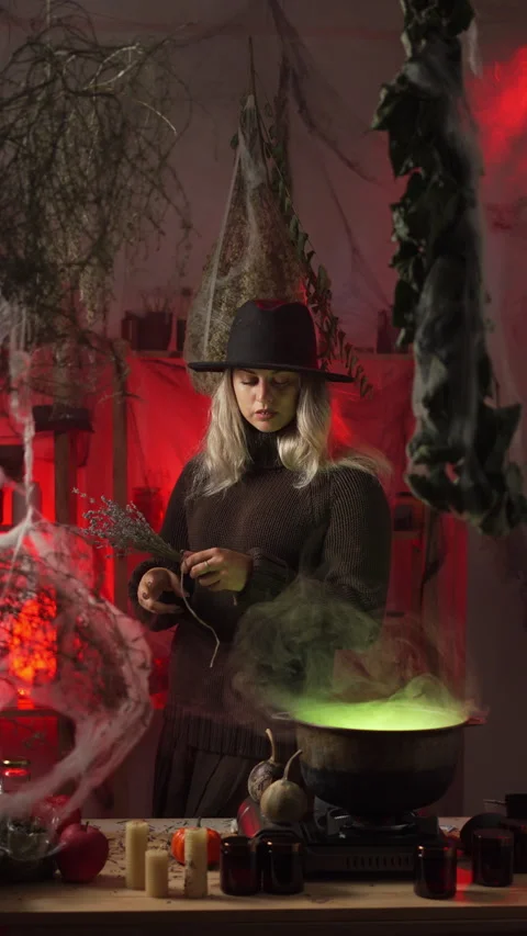 Modern witch at home, amidst cobwebs and dried herbs, prepares a poison or .. 動画素材 345428679