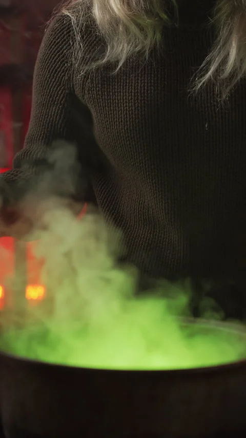 Modern witch in home, surrounded by cobwebs and dried herbs, brewing a pois.. Stock Footage 345431953