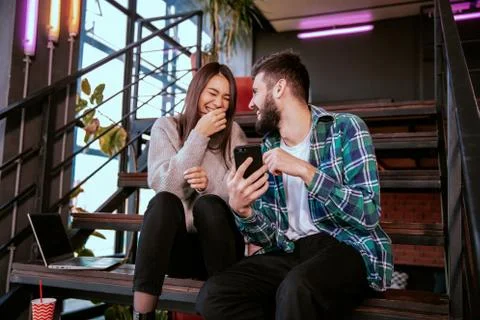 On the modern work office studio one good looking guy and pretty lady smiling Stock Photos