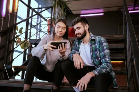 On the modern work office studio one good looking guy and pretty lady smiling Stock Photos