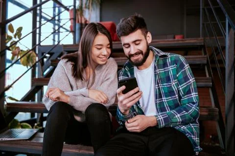 On the modern work office studio one good looking guy and pretty lady smiling Stock Photos
