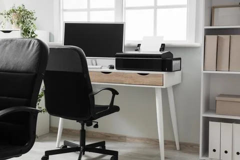 Modern workplace with computer and printer near window in office Stock Photos