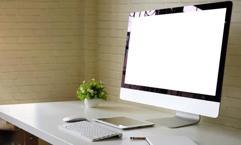 Modern workplace with computer pc, books, and coffee cup on white table.. Stock Photos