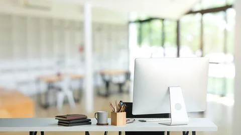 Modern workplace with computer pc, coffee cup, books and office supplies on w Stock Photos
