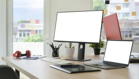 Modern workplace with white blank computer screen, laptop and graphic table.. Stock Photos