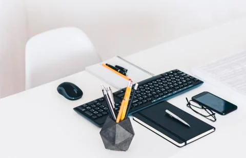 Modern workplace: white table, keyboard laptop computer, concrete holder with Stock Photos