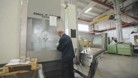 Modern workshop with CNC machines. A man works on a CNC machine. The worker 動画素材 214416093