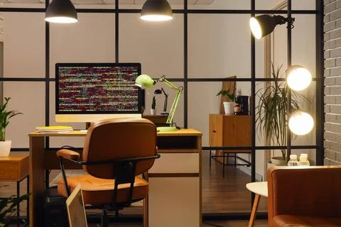 Modern workspace with computer displaying code 스톡 사진