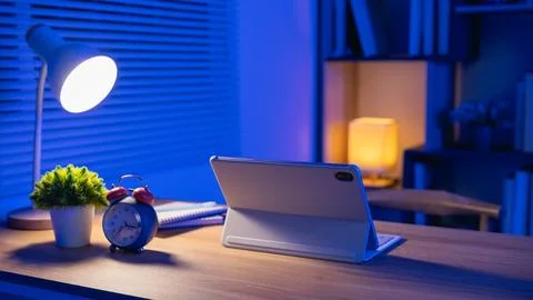 Modern workspace with digital tablet, alarm clock, desk lamp, potted plant,.. Stock Photos
