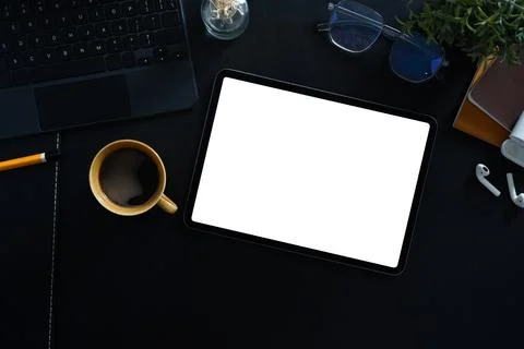 Modern workspace with digital tablet, coffee cup and stationery on black leather Stock Photos