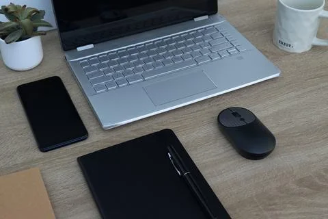 Modern workspace with laptop, notebook, and smartphone on wooden desk Stock Photos