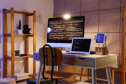 Modern workspace with multiple screens showing programming code 스톡 사진