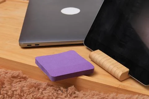 Modern workspace setup with laptop, tablet, and purple notepad on wooden desk Foto stock