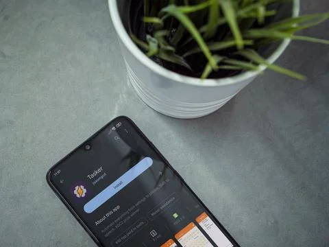 Modern workspace with smartphone with Tasker app play store page on marble .. Stock Photos