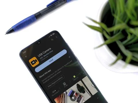 Modern workspace with smartphone with USB Camera app play store page on whi.. Stock Photos